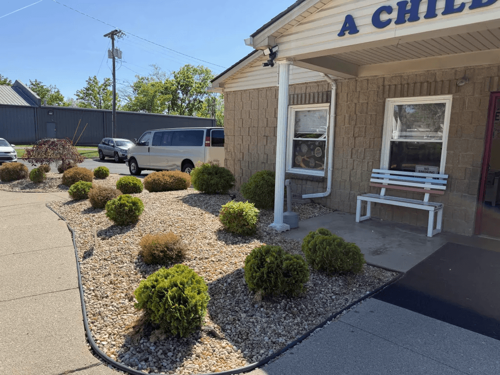 Commercial building entrance with river rock and rounded shrub plantings